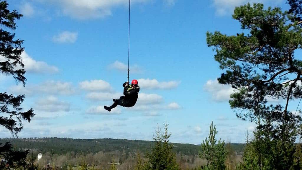 En person hänger i en jättelång vajer så det blir som en jättegunga.