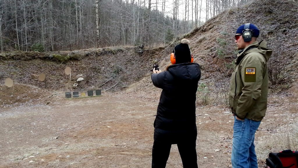 En person testar att skjuta pistol. En annan övervakar så han gör rätt.